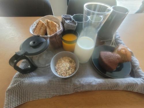 ein Frühstück aus Brot und Milch auf einem Tisch in der Unterkunft Ti Ana Chambre Bohème in Évran