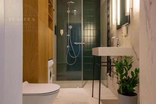a bathroom with a shower and a toilet and a sink at Fragola Apartments Old Town in Kraków