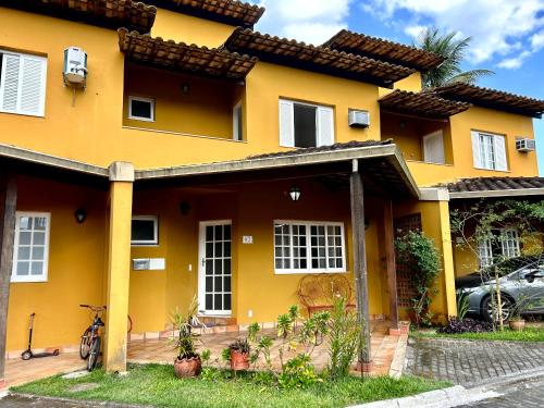 a yellow house with a car parked in front of it at Sol & Aconchego Paraty in Paraty