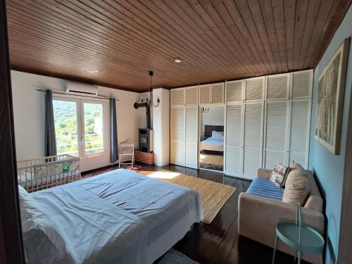 プラタモナスにあるAppartement Platamonのベッドとソファと窓のある寝室