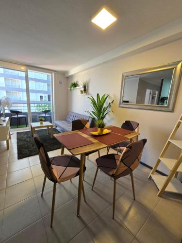 a living room with a wooden table and chairs at Espléndido y central Departamento Familiar in Rancagua