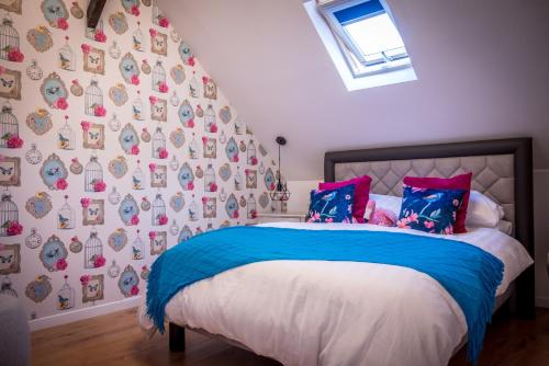 a bedroom with a bed with blue and pink pillows at Gite Belle Vue, Sourdeval in Sourdeval