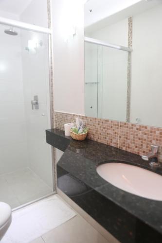 a bathroom with a sink and a mirror at Alfa Hotel Teresina in Teresina