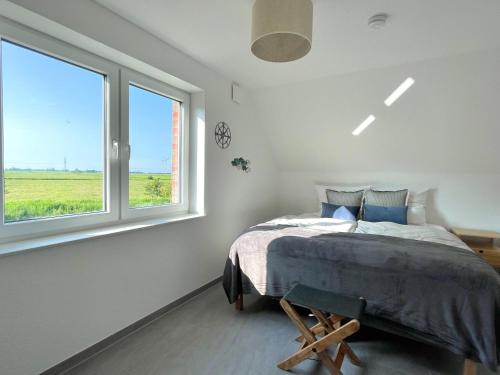 une chambre avec un lit et une fenêtre dans l'établissement Ferienhaus Meerwunder, à Wangerland