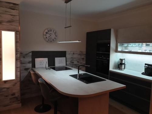 a kitchen with a table and a clock on the wall at Luxus Spa Penthouse Sundowner in Göhren-Lebbin