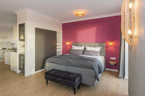 a bedroom with a bed and a pink wall at Luxus Spa Penthouse Sundowner in Göhren-Lebbin