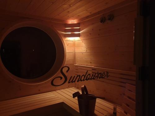 a sauna with a mirror and a light on the wall at Luxus Spa Penthouse Sundowner in Göhren-Lebbin