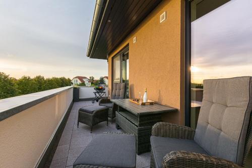 a patio with chairs and a table on a balcony at Luxus Spa Penthouse Sundowner in Göhren-Lebbin