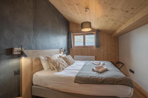 a bedroom with a bed with two dolls on it at Alpe d'Huez Houses - Hameau de Clotaire - Le cocon blanc - Duplex 5 chambres - cheminée wellness - Ski aux pieds in L'Alpe-d'Huez