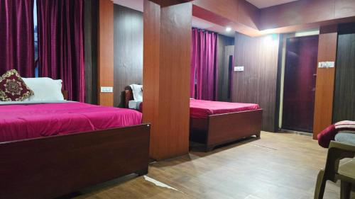 a room with two beds with red sheets and a mirror at Mananya Cottage Ooty in Ooty