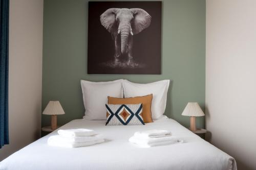 a bed with a black and white picture of an elephant at Escale de Giulia in Beaune
