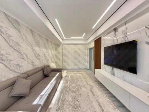 a living room with a couch and a flat screen tv at Жк Development in Bishkek