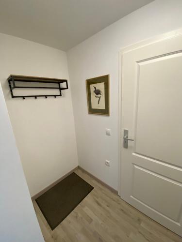 a white room with a door and a rug at Brennerei Federow in Federow