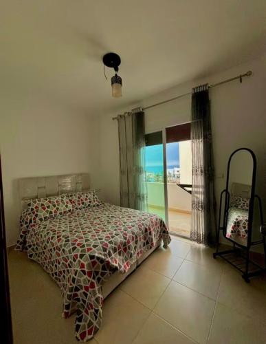 a bedroom with a bed and a large window at Mediterranean summer in Oued Laou