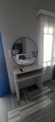 a white room with a mirror and a table at Pension Selenti in Tinos Town