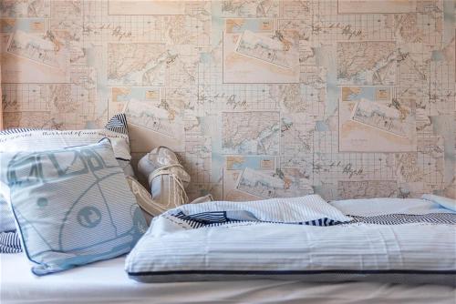 a bed with striped pillows and a wall with a wallpaper at Strandlust in Zingst