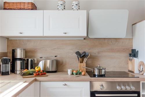 a kitchen with white cabinets and vegetables on a counter at Strandlust in Zingst