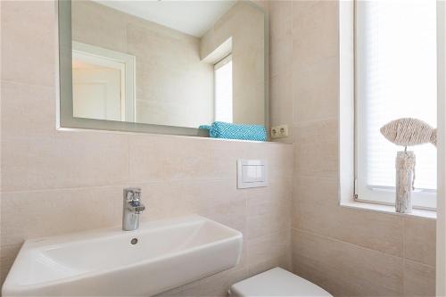 a bathroom with a sink and a mirror and a toilet at Strandlust in Zingst