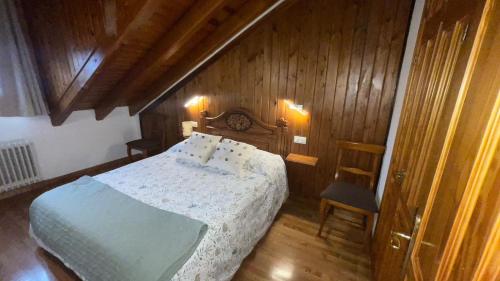 a bedroom with a bed and a wooden wall at Apartamento céntrico en Benasque in Benasque