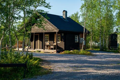 a brown house with a driveway in front of it at Wilderness cottage 6 people in Kiruna