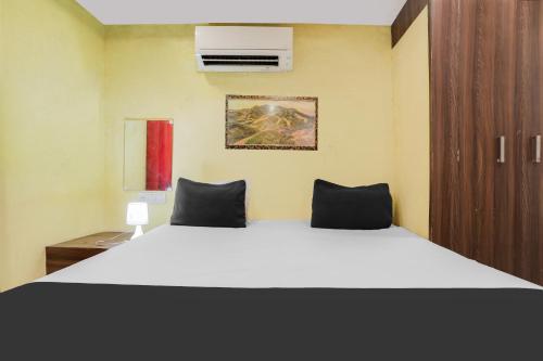 a bedroom with a large white bed and a cabinet at Hotel O Gyan Regency in Raipur