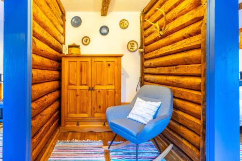a blue chair in a room with wooden walls at Pension La Roata in Gura Humorului