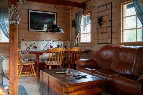 a living room with a leather couch and a table at Wilderness cottage 6 people in Kiruna