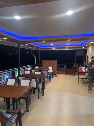 a dining room with tables and chairs and blue lights at Local point homestay in Pokhara