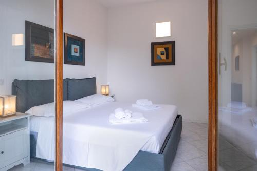 a bedroom with a white bed and a mirror at Casa Vacanze Panorama in Brunate