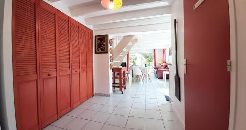 un couloir avec des portes rouges et une salle à manger dans l'établissement Brennig, à Penmarcʼh