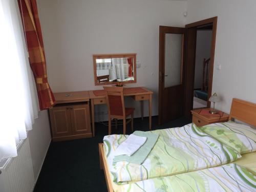 a bedroom with a bed and a desk with a mirror at Penzion Kiska Levočská Dolina, ubytovanie v súkromí in Levoča