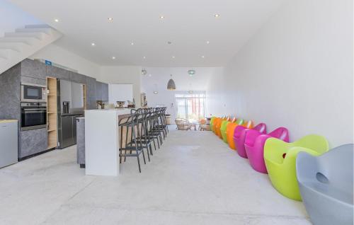 Il comprend un salon avec des chaises colorées et une cuisine. dans l'établissement 1 Bedroom Amazing Home In Loupian, à Loupian