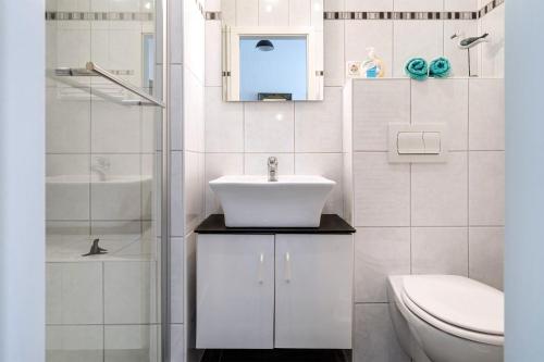 a white bathroom with a sink and a toilet at FeWo Annette in Riepe in Ihlow