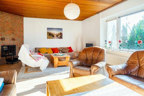 a living room with a couch and chairs at FeWo Annette in Riepe in Ihlow