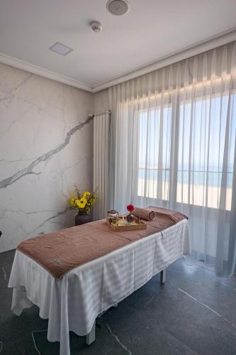 a bedroom with a bed with a table and a window at Mirage Beach Spa Hotel in Eforie Nord