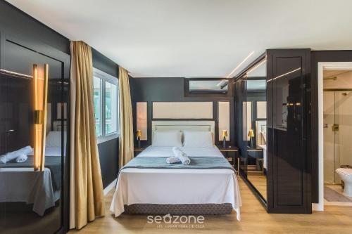 a bedroom with a large bed and a bathroom at Apartamentos a 850m da Praia Brava - RCX in Cabeçudas