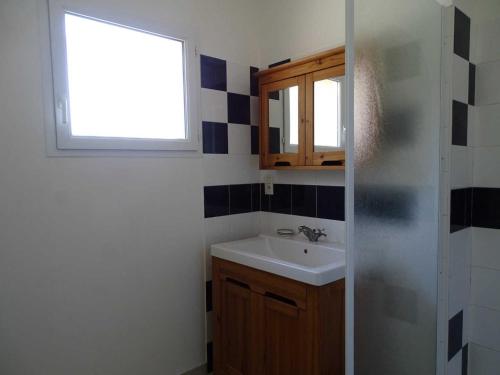 Un baño con lavabo y ventana. en Villa bellevue, en Fanjeaux