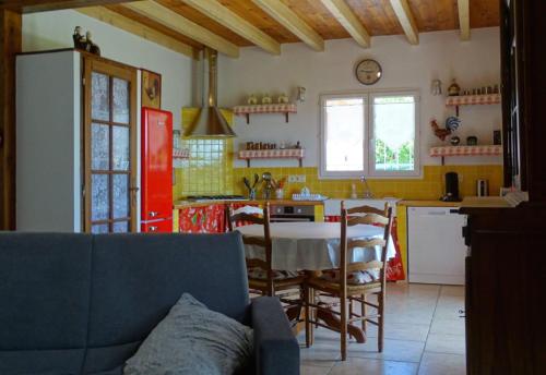 Una sala de estar con una mesa y una cocina. en Villa bellevue, en Fanjeaux