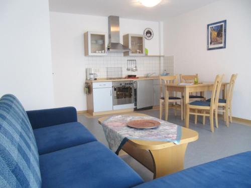 a living room with a blue couch and a table at Ferienanlage Harzfreunde in Allrode