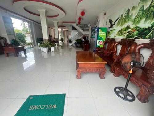 a lobby with a table and chairs in a building at Khách sạn Nhất Phương 2 in Ấp Ðông An (1)