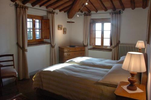 サン・カシャーノ・イン・ヴァル・ディ・ペーザにあるArchipettoliのベッドルーム1室(ベッド1台、ランプ付きテーブル付)