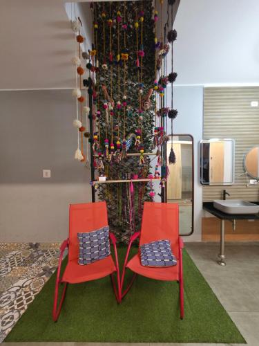 two red chairs in front of a christmas tree at sabina nuevo aeropuerto x12 in Lima