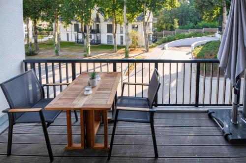 ein Holztisch und zwei Stühle auf einem Balkon in der Unterkunft Bernsteinquartier - Wohnung 87 in Ostseebad Kölpinsee