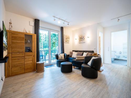 ein Wohnzimmer mit Couch und Stühlen in der Unterkunft Bernsteinquartier - Wohnung 87 in Ostseebad Kölpinsee