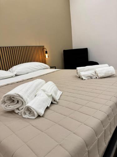 a bedroom with two beds with white towels on them at Rocca Rooms in Catania