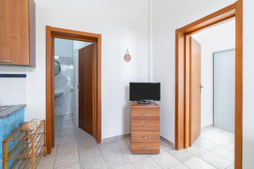 a bathroom with a television on a wooden dresser with a televisionicterictericter at Casa Patrizia in centro a Marzamemi in Marzamemi