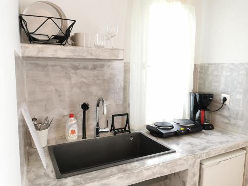 a kitchen counter with a sink and a window at Amorgos Meltemi Apartments in Amorgos