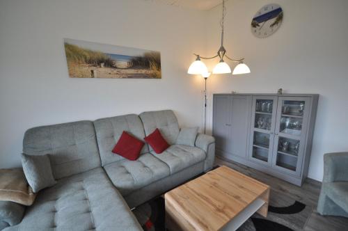 a living room with a couch and a table at Nr 201 - Ferienhaus Am Tief in Neuharlingersiel