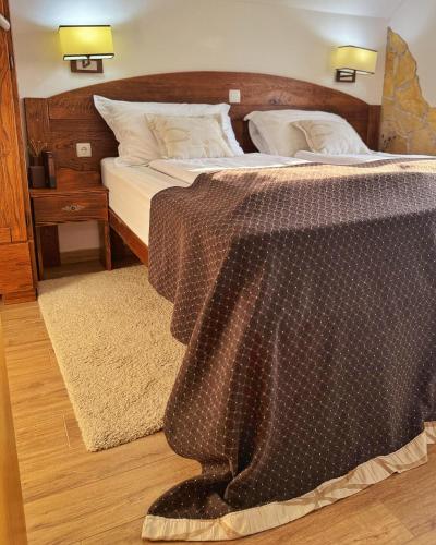 a bedroom with a bed with a table on it at Etno Garden Apartments in Plitvička Jezera