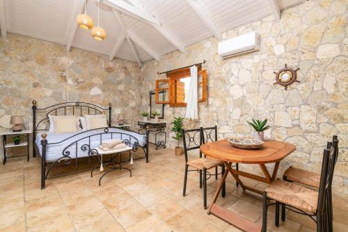 a bedroom with a bed and a table and chairs at Villa Sea Stone by Villa Plus in Makris Gialos